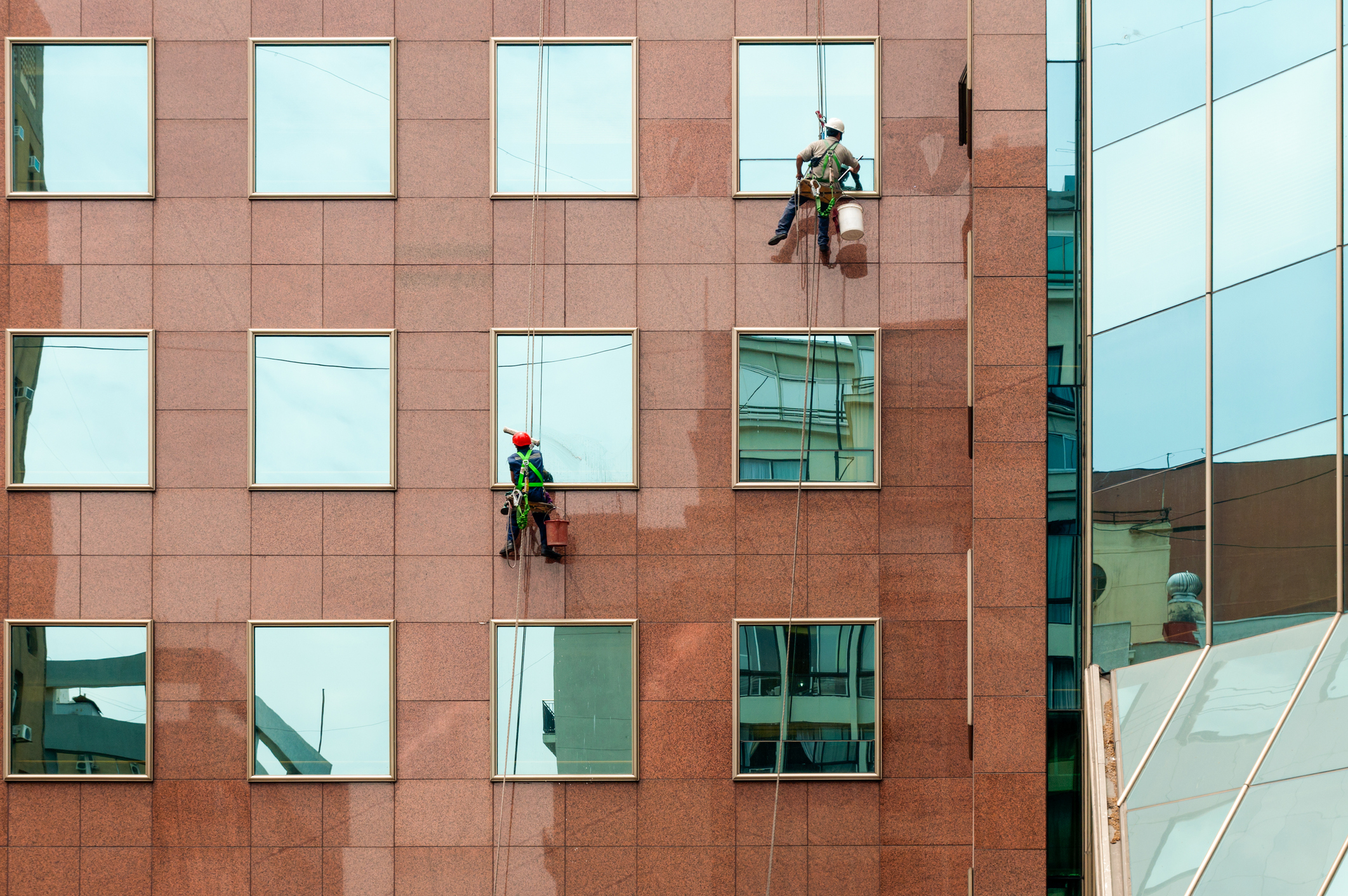 Santiago, Chile - December 01, 2012: Two window cleaners at work and offices building at December 01, 2012, square frame.